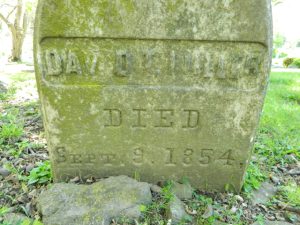 Weathered grave marker engraved with a date.